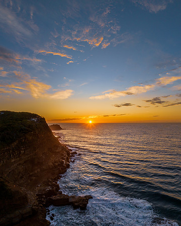 Ocean sunrise with rock platform and clouds
