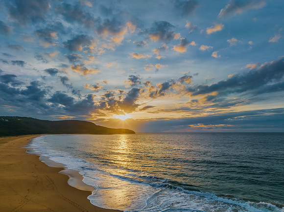 Sunrise seascape with clouds and gentle surf