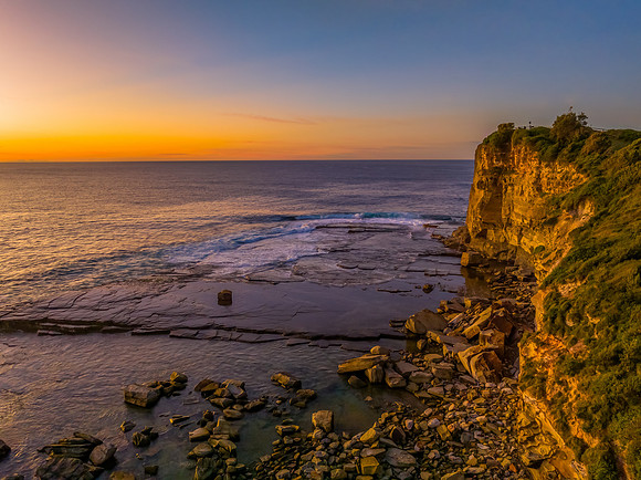 Sunrise over the calm sea and rocky Inlet