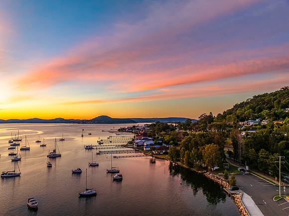 Aerial sunrise waterscape with boats and high cloud