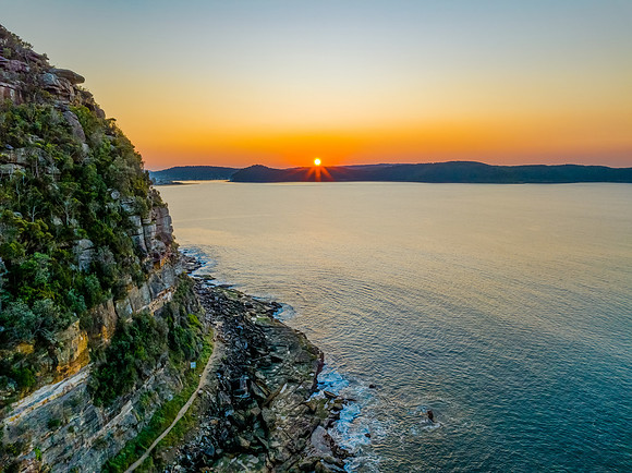 Aerial sunrise over the calm sea and smoke haze clear sky