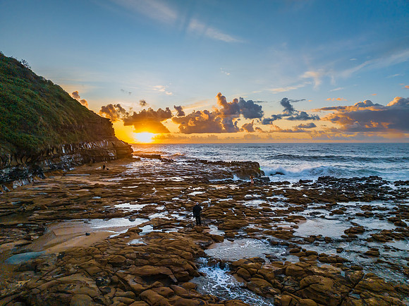 Sunrise and clouds over the ocean and rock platform