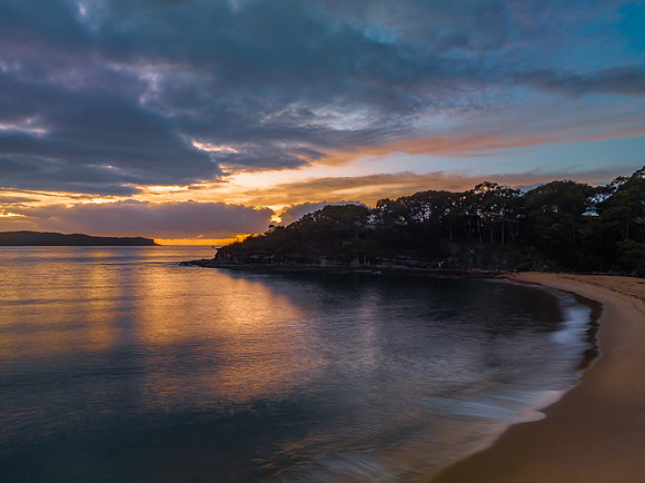 Aerial sunrise seascape with calm seas and a mix of high and low