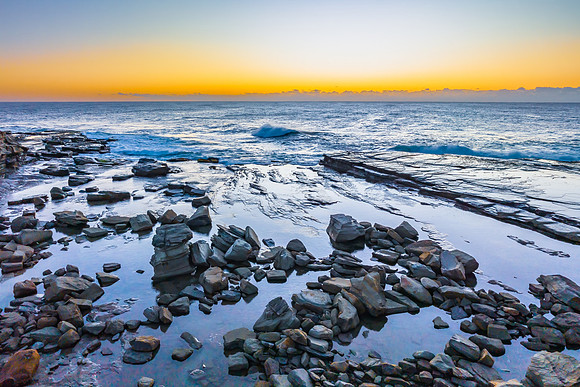 Sunrise over the sea and rocky Inlet with clear skies and a low