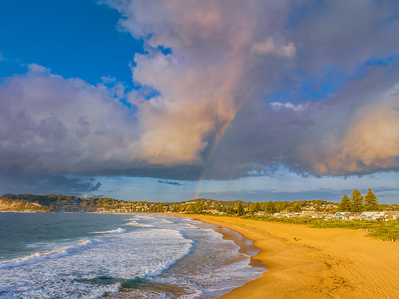 Early morning views at the beach with clouds and a rainbow
