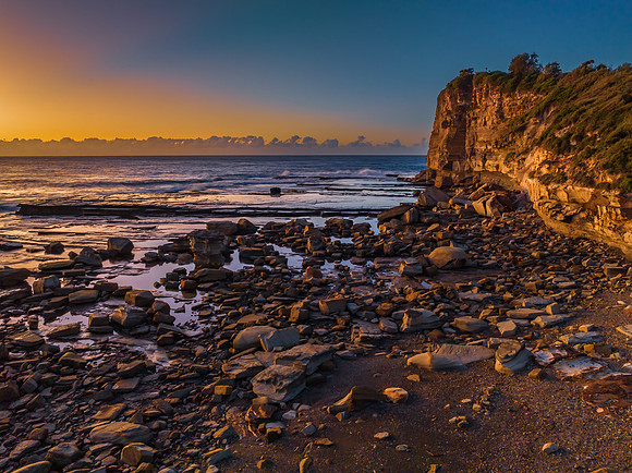 Sunrise over the sea and rocky Inlet with clear skies and a low