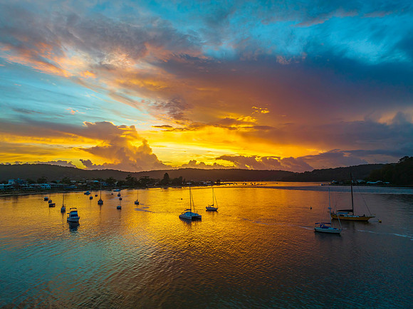 Aerial sunrise waterscape with boats, colour and clouds