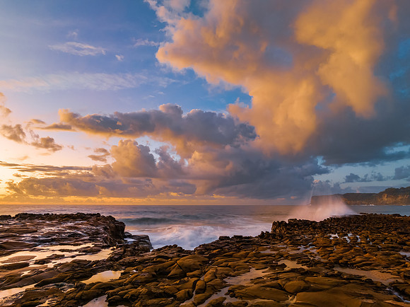 Sunrise and clouds over the ocean and rock platform