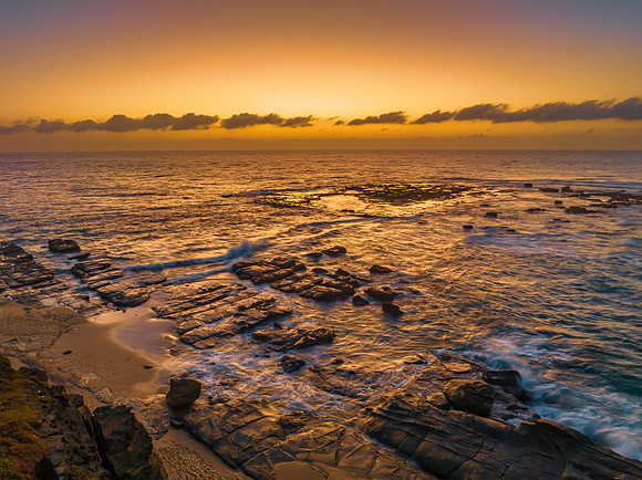 Aerial sunrise seascape with  high tide and rock platform