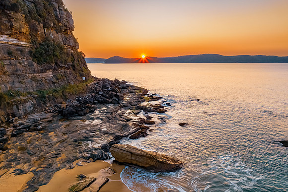 Aerial sunrise over the calm sea and smoke haze clear sky