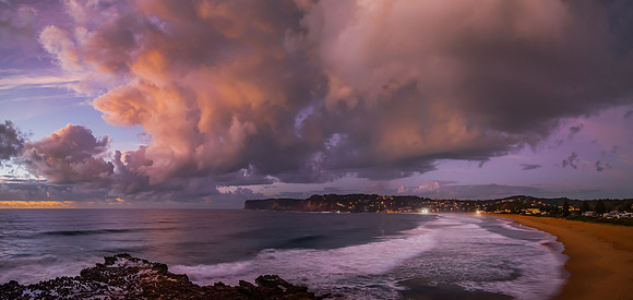 Sunrise and clouds over the ocean and rock platform