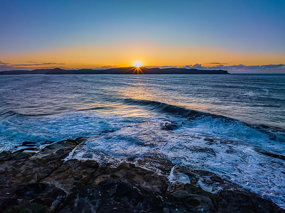 Aerial sunrise over the sea from the headland