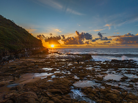 Sunrise and clouds over the ocean and rock platform