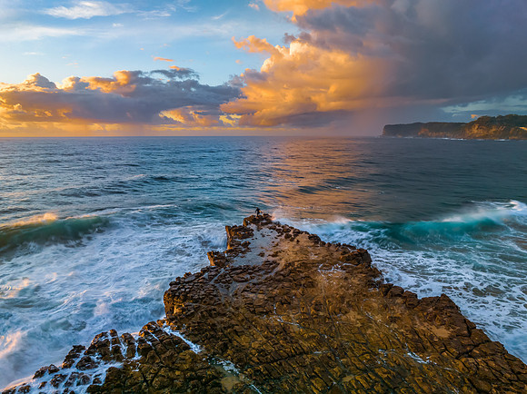 Sunrise and clouds over the ocean and rock platform