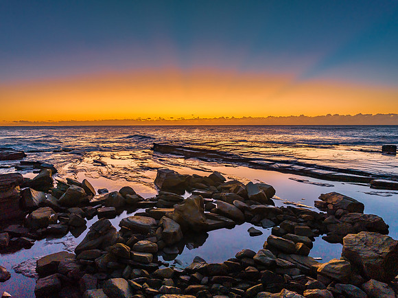 Sunrise over the sea and rocky Inlet with clear skies and a low