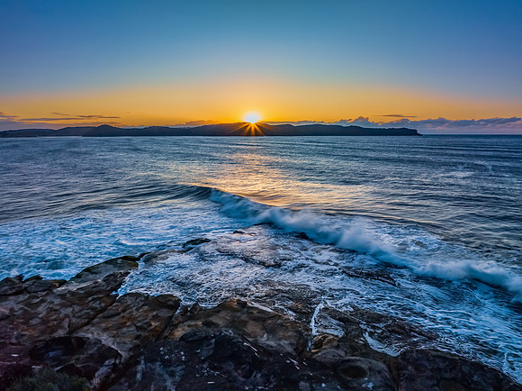 Aerial sunrise over the sea from the headland