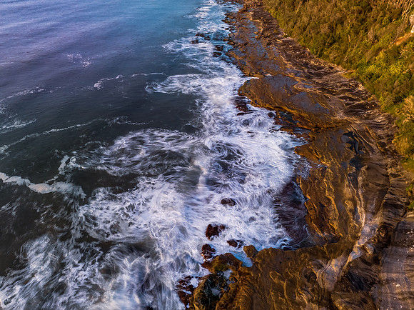 Aerial sunrise over the sea from the headland