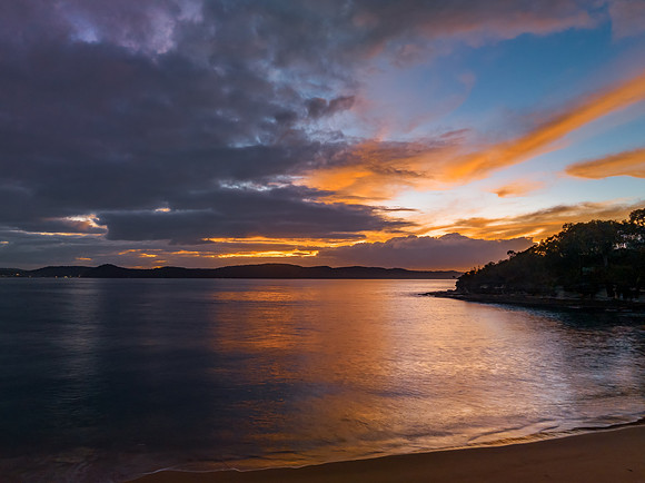 Aerial sunrise seascape with calm seas and a mix of high and low