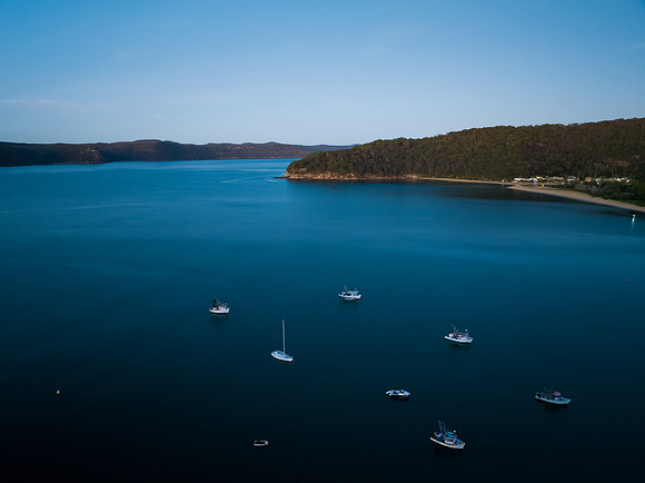 Dawn at the bay with boats and mountain ranges from Patonga