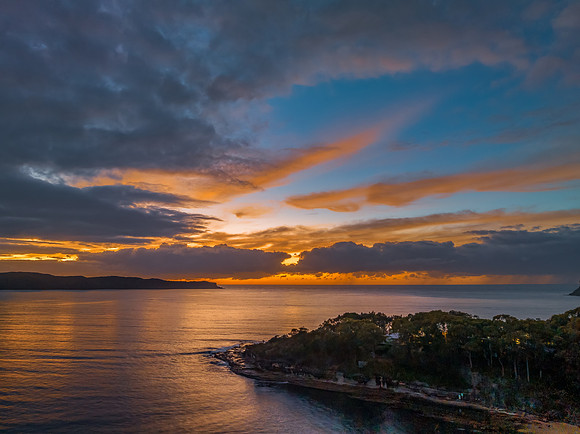 Aerial sunrise seascape with calm seas and a mix of high and low