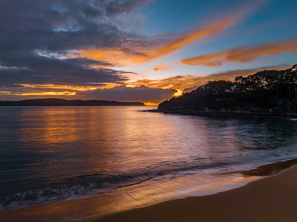 Aerial sunrise seascape with calm seas and a mix of high and low