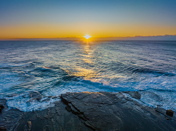 Sunrise over the sea and rocky Inlet with clear skies and a low