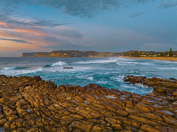 Ocean sunrise with rock platform and clouds