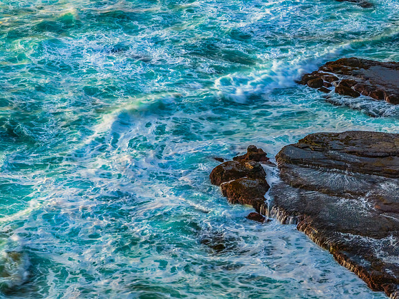 Sunrise at the beach with waves and a smattering of clouds