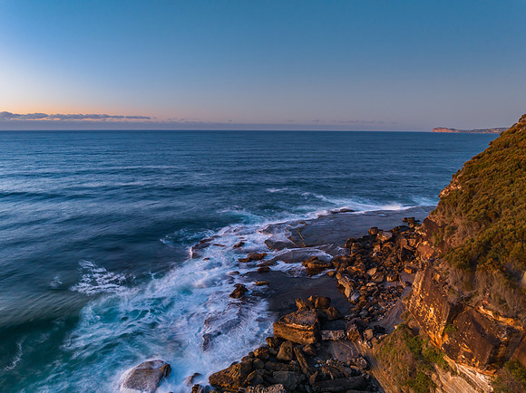 Sunrise seascape with waves and a low cloud bank