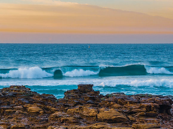 Ocean sunrise with wave amd pastel coloured sky
