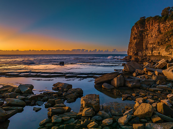 Sunrise over the sea and rocky Inlet with clear skies and a low