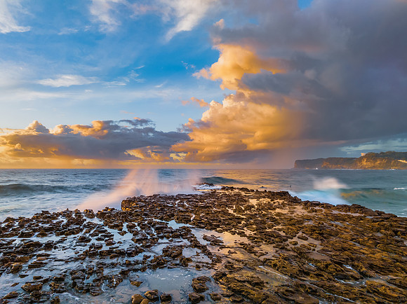 Sunrise and clouds over the ocean and rock platform