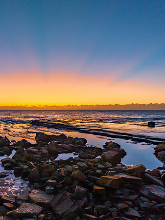 Sunrise over the sea and rocky Inlet with clear skies and a low