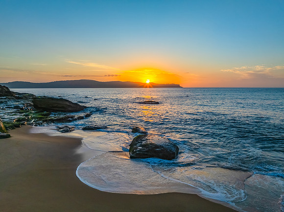 Aerial sunrise at the seaside with light scattered high cloud an
