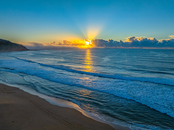 Sunrise over the sea with a low cloud bank and fog
