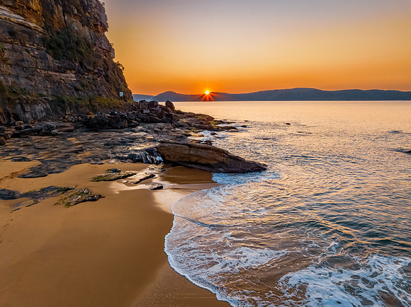 Aerial sunrise over the calm sea and smoke haze clear sky