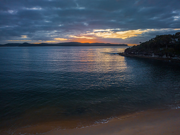 Aerial sunrise seascape with calm seas and a mix of high and low