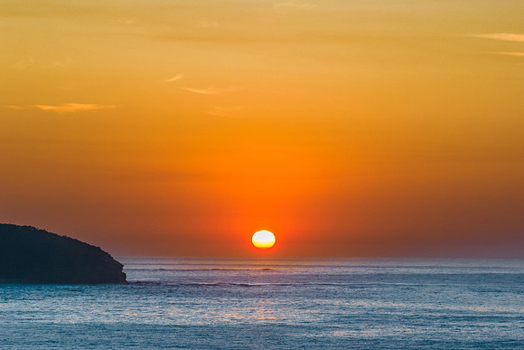 Soft hazy sunrise seascape and orange sky and full sun