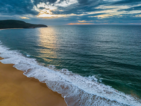 Sunrise seascape with clouds and gentle surf