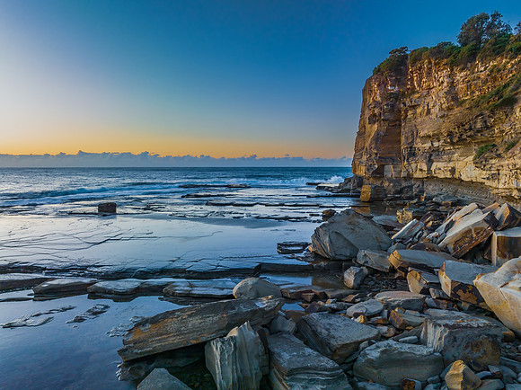 Sunrise over the sea and rocky Inlet with clear skies and a low