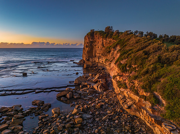 Sunrise over the sea and rocky Inlet with clear skies and a low