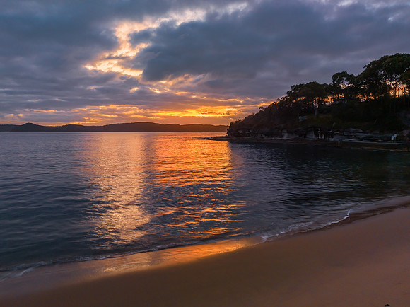 Aerial sunrise seascape with calm seas and a mix of high and low