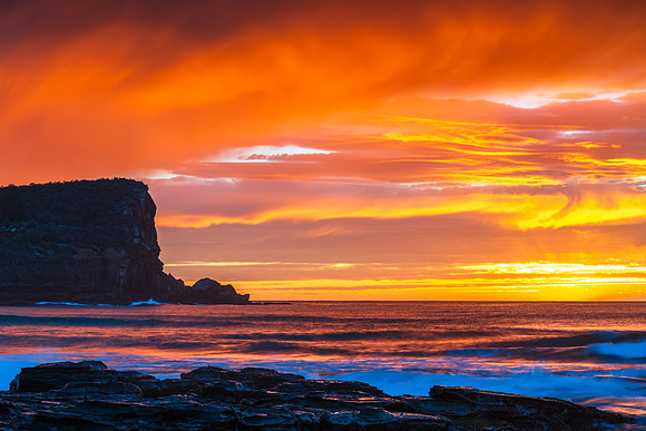 Winter sunrise by the sea shore with rain clouds