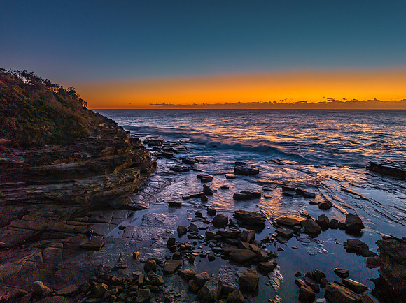 Sunrise over the sea and rocky Inlet with clear skies and a low