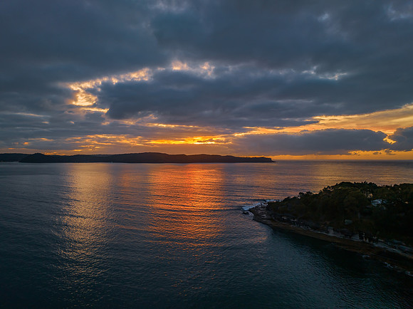 Aerial sunrise seascape with calm seas and a mix of high and low