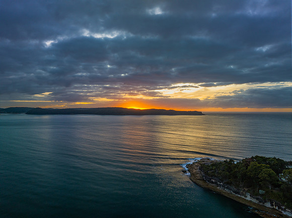 Aerial sunrise seascape with calm seas and a mix of high and low