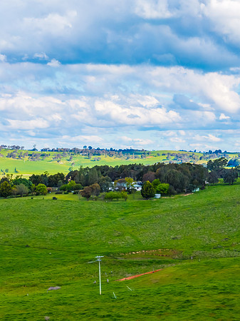 Afternoon aerial views over the green countryside with clouds in