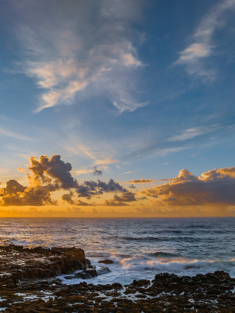 Sunrise and clouds over the ocean and rock platform