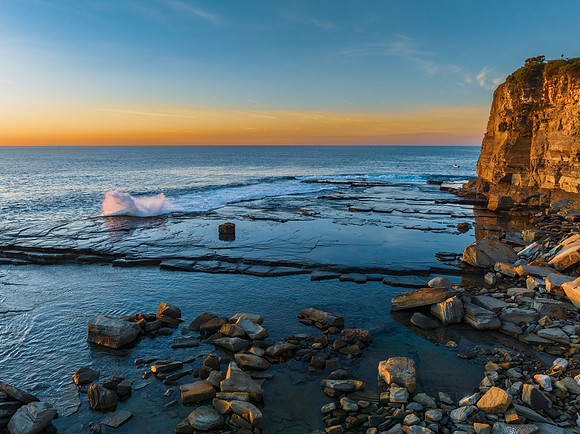 Sunrise over the calm sea and rocky Inlet