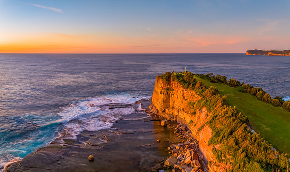 Sunrise over the calm sea and rocky Inlet
